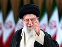 Iranian Supreme Leader Ayatollah Ali Khamenei waves after casting his vote for the preside