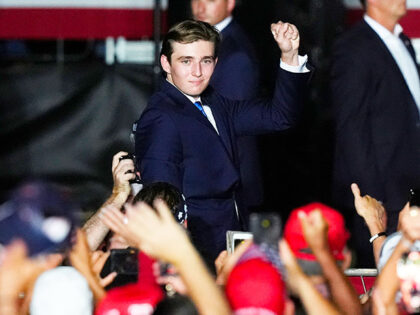 Barron Trump raises a clenched fist after he is introduced by his father, Republican presi