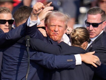 former President Donald Trump is helped off the stage at a campaign event in Butler, Pa.,