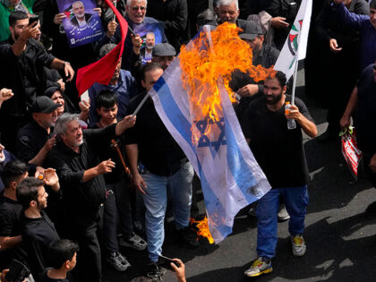 Iranians burn a representation of the Israeli flag during the funeral ceremony of Hamas le