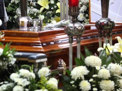 A mourner stands next to the coffin containing the remains of slain journalist Victor Manu