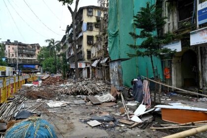 Debris from the partially collapsed Rubbunnisa Manzil building lies along a street after m