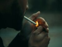 close-up photography of man using cigarette during daytime