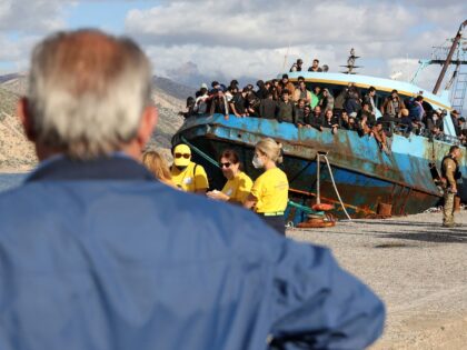 Rescued refugees and migrants stand aboard a boat at the town of Paleochora, southwestern