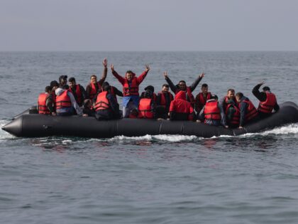 AT SEA, ENGLAND - AUGUST 04: An inflatable craft carrying migrants crosses the shipping la