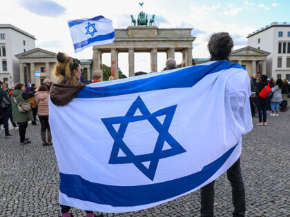 People hold Israeli flag as they gather to protest against the Operation Al-Aqsa Flood lau