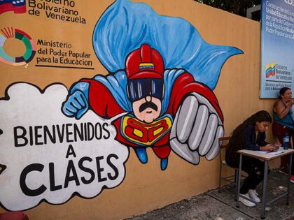 A girls sits near a "Súper Bigote" (Super Moustache) cartoon at a polling station in 23 d