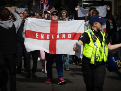 MANCHESTER, UNITED KINGDOM - 2024/08/03: A man holds a St Georges flag during a Stand Up T