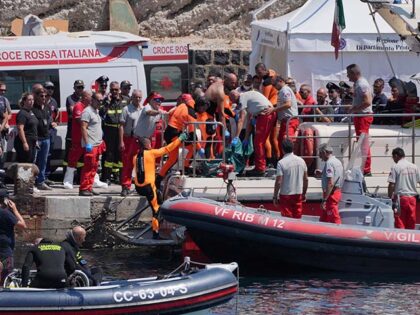 A body bag is brought ashore at the harbour in Porticello by rescue workers on the fifth d