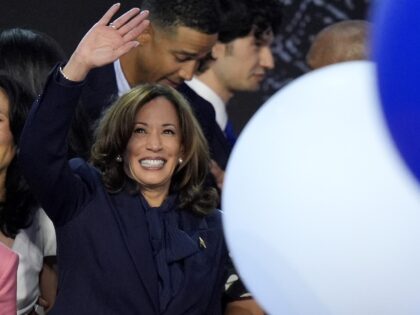 Democratic presidential nominee Vice President Kamala Harris waves surrounded by balloons