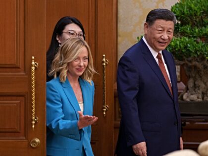 China's President Xi Jinping (R) walks with Italy's Prime Minister Giorgia Meloni (L) for