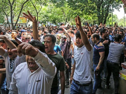 A group of protesters chant slogans at the old grand bazaar in Tehran, Iran, Monday, June