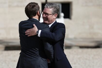 Starmer (R) was greeted with a hug by Macron