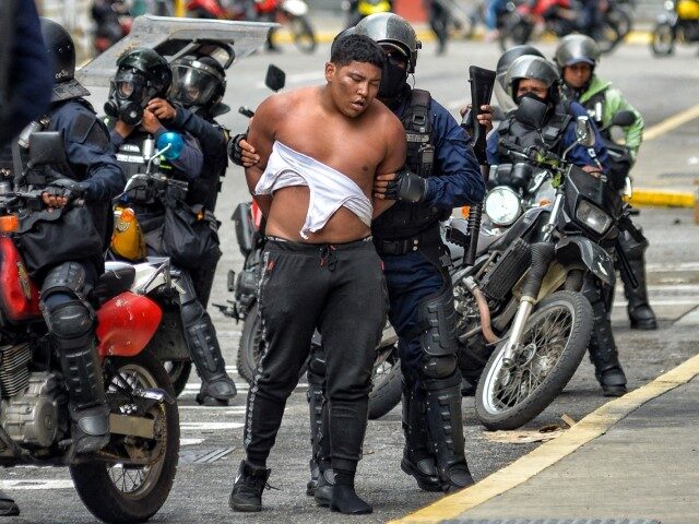 Members of the Bolivarian National Police detain a man during a demonstration called by th